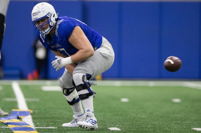 Kansas redshirt senior offensive lineman Dominick Puni (67) hikes the ball during practice Thursday.